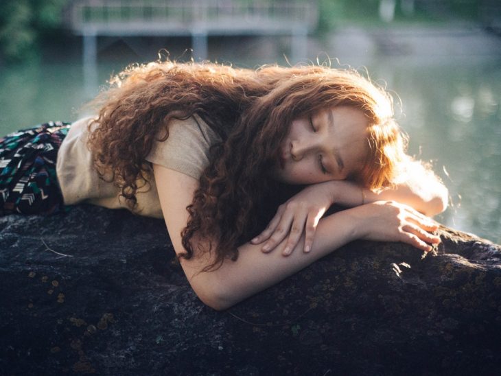 chica recostada en una piedra