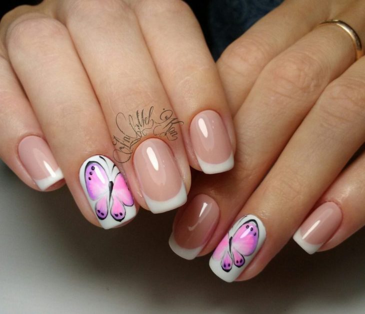 Uñas pintadas con esmalte blanco y transparente con diseño de mariposas