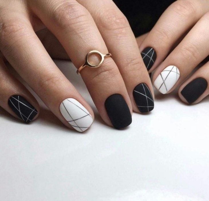 Uñas pintadas de negro y blanco con diseño de líneas rectas minimalistas