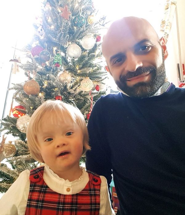 Luca Trapanese posando junto a su hija alba a un lado del árbol de navidad 