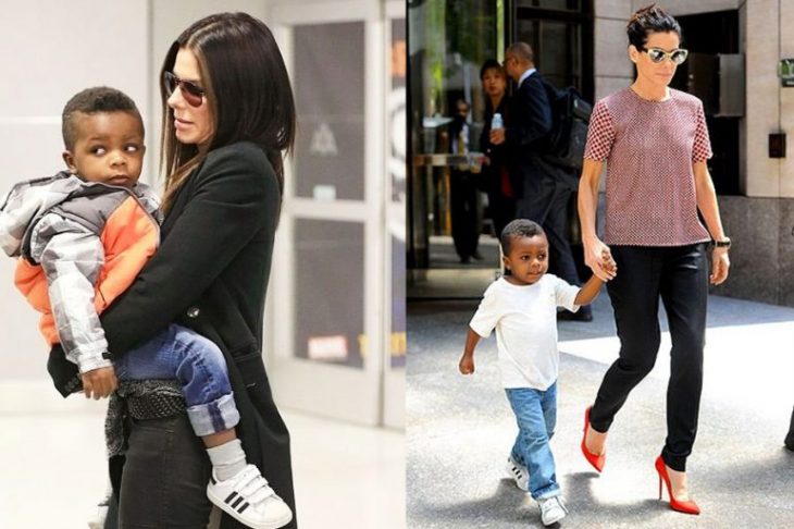 mujer con cabello negro y lentes cargando a niño 