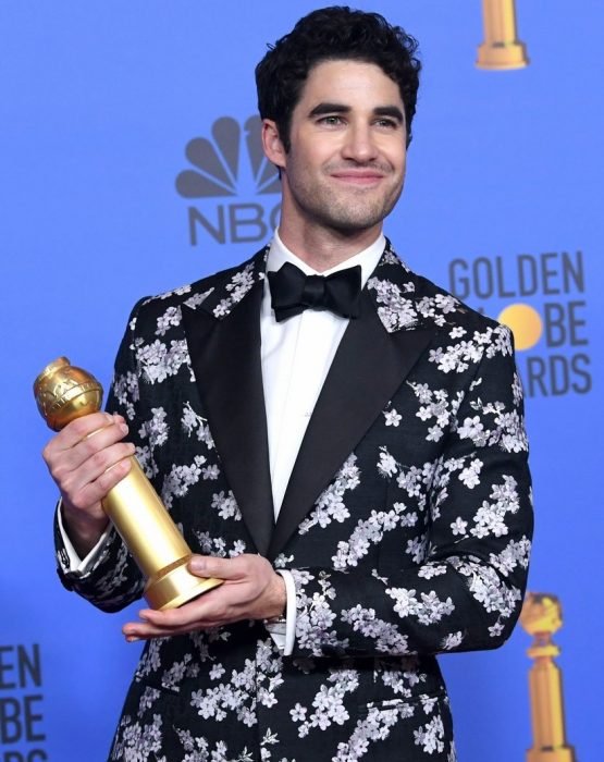 hombre con saco blanco con negro y globo de oro 