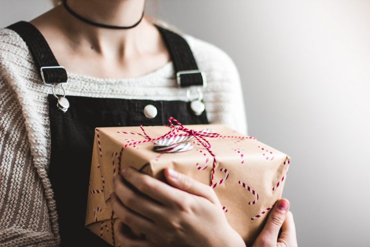 chica sosteniendo una caja de regalo