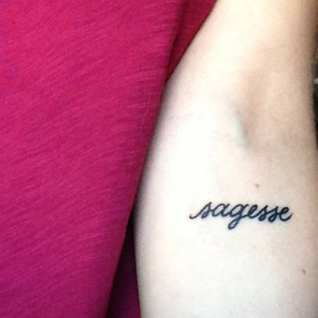 mujer con tatuaje de frase en el brazo