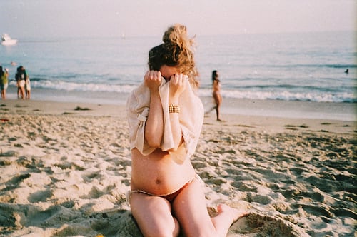 mujer embarazada en arena y playa