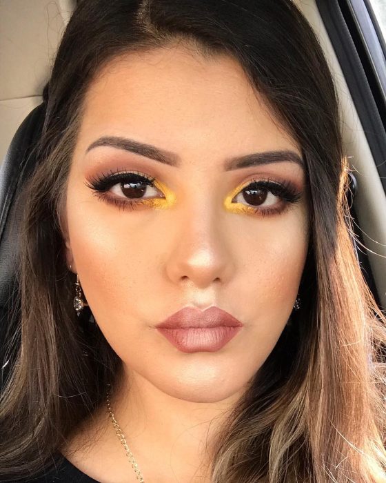 mujer con maquillaje amarillo en el lagrimal 