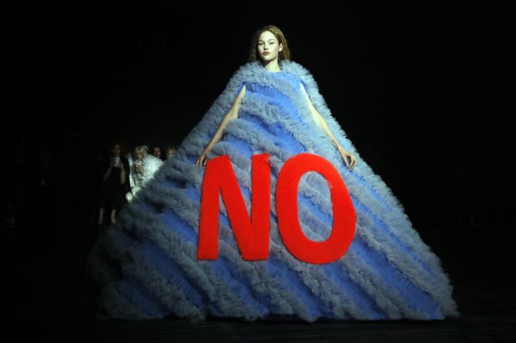 mujer pasarela de modas con vestido color azul con letras roja 