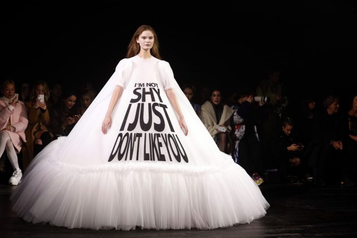 mujer pasarela de modas con vestido color blanco letras 