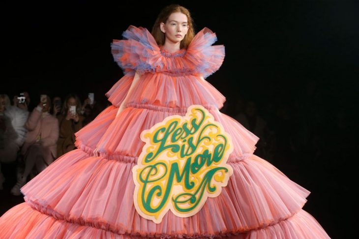 mujer pasarela de modas con vestido color rosa con letras 