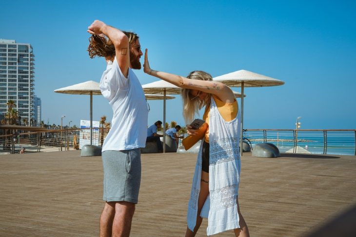 pareja de novios jugando en un muelle 