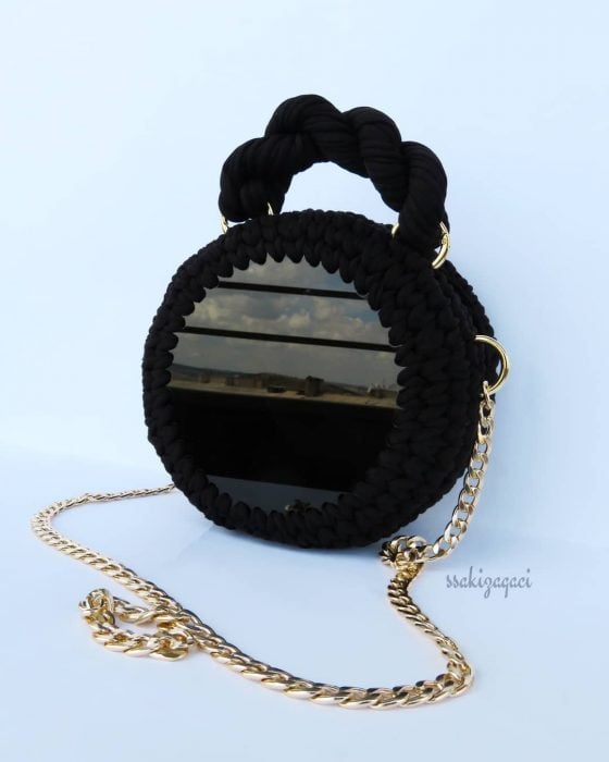 bolso negro circular con cadena dorada 