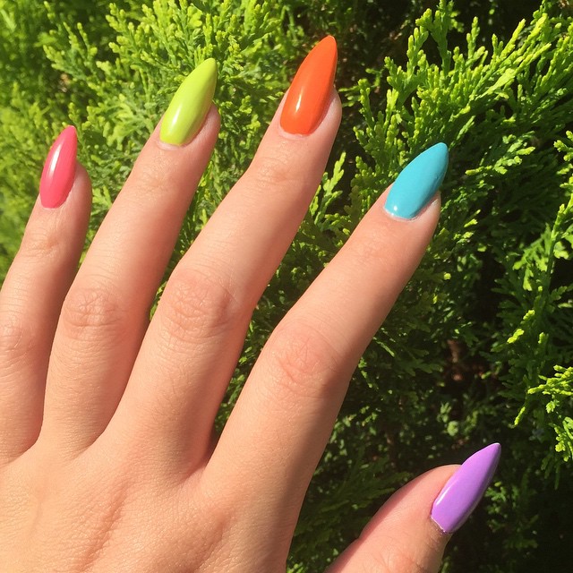 manos de mujer con uñas de colores arcoiris