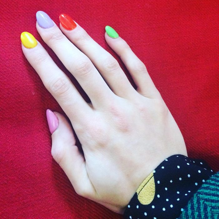 manos de mujer uñas de colores arcoiris 