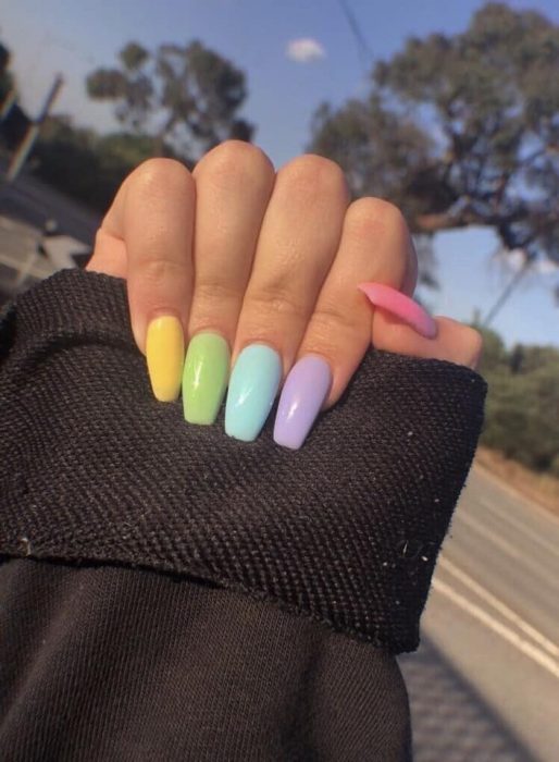 manos de mujer con uñas de colores 