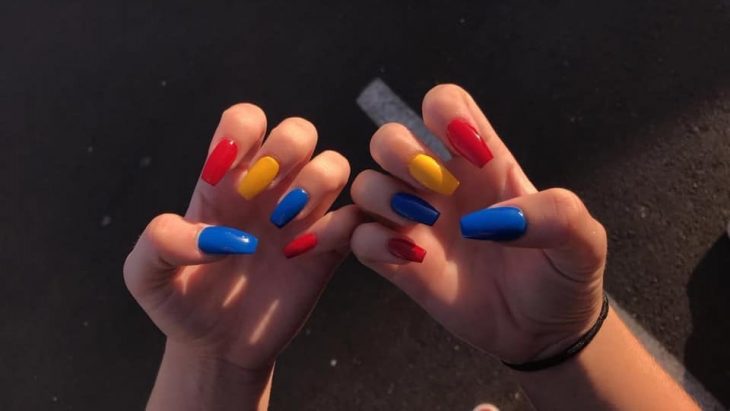 manos de mujer con uñas de colores 