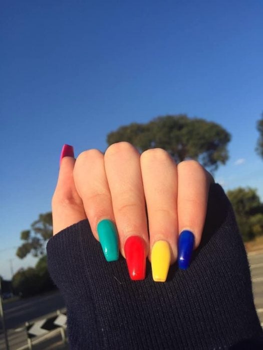 manos de mujer con uñas de colores 