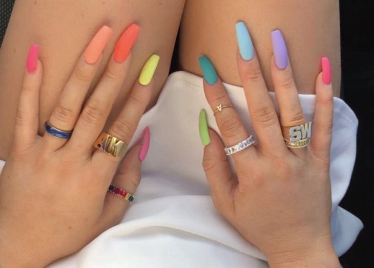 manos de mujer con uñas de colores pastel