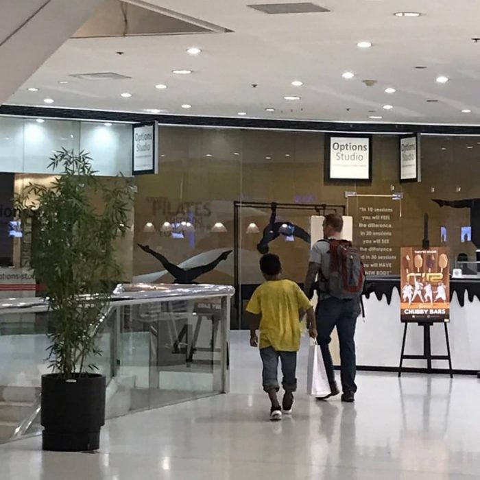 Niño de la calle y turista saliendo de una tienda