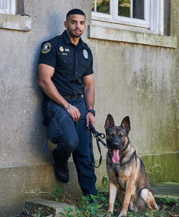 Oficial de policía con uniforme junto a un perro pastor alemán