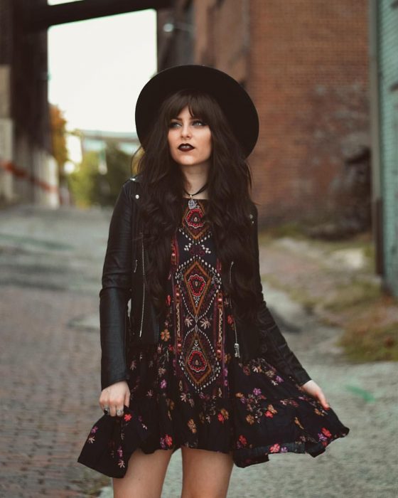 Mujer con vestido tradicional, chaqueta de cuero y sombrero