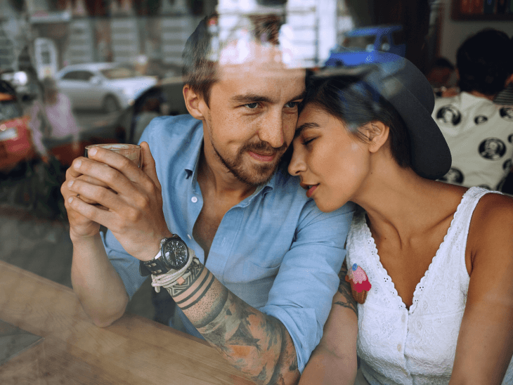 Pareja de novios con tatuajes tomando café