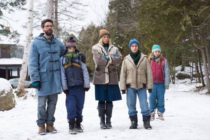 Familia jugando en la nieve durante invierno