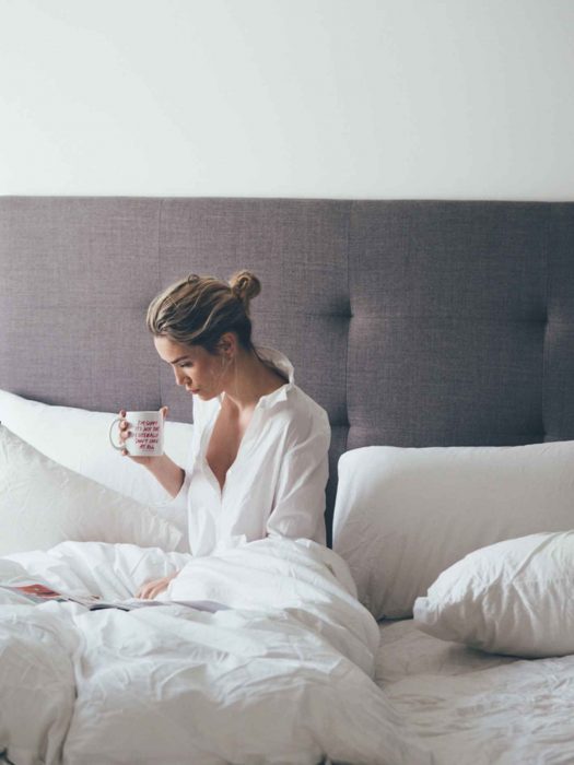 Mujer rubia sentada bebiendo una taza de café