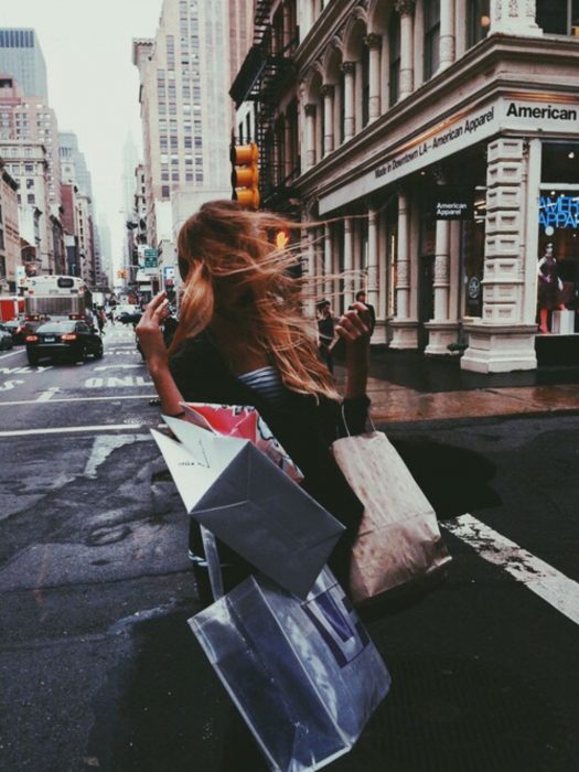 Mujer en la calle con bolsas de shopping