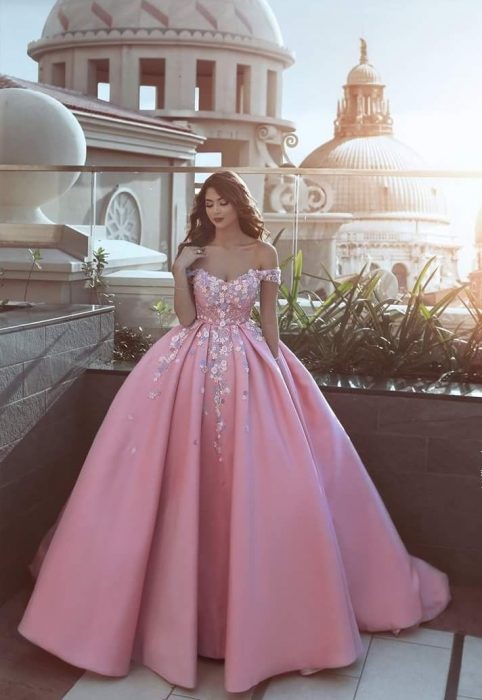 Chica con vestido para XV años rosa de corte princesa y con adornos de flores