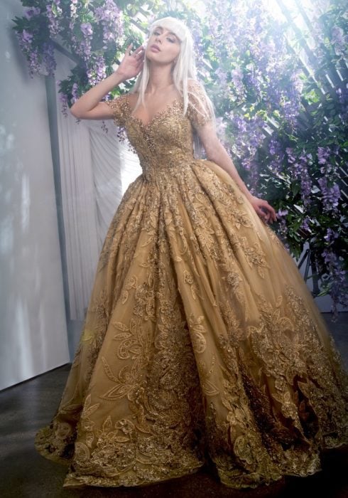 Chica con vestido para XV años de corte princesa dorado con encaje de flores
