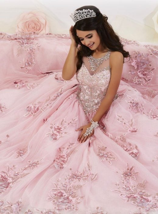 Chica con vestido para XV años de corte princesa colo rosa con pedrería y corona