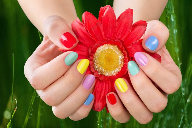 manos de mujer uñas de colores arcoiris 