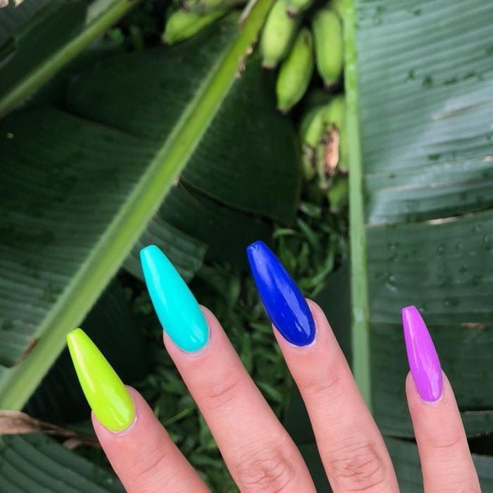 manos de mujer con uñas de colores azul verde