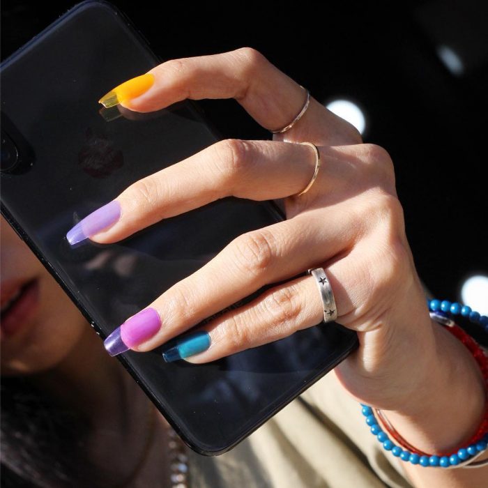 manos de mujer uñas de colores arcoiris 