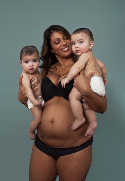 Mujer con sus dos bebés en brazos después de semanas de parto