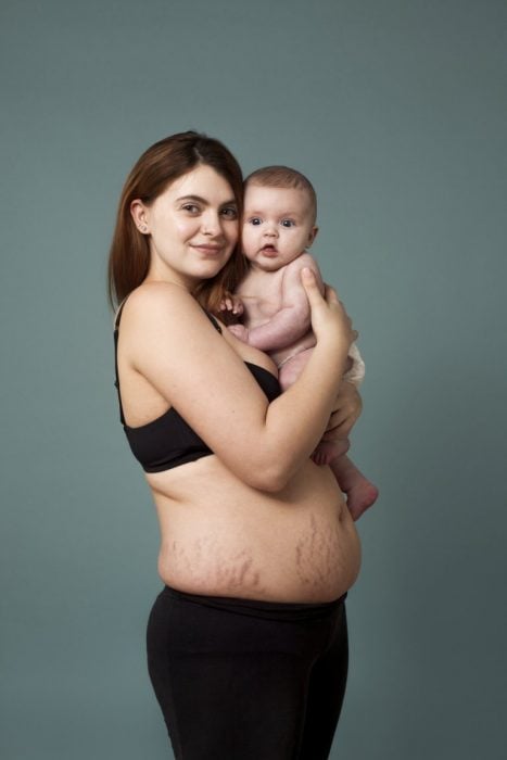 Mujer con su bebé en brazos después de semana de dar a luz