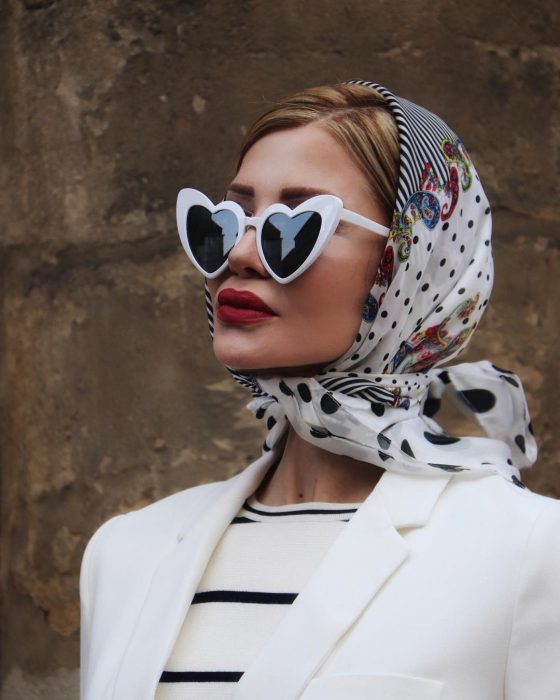 Mujer rubia con bandana en la cabeza y lentes de sol en forma de corazón