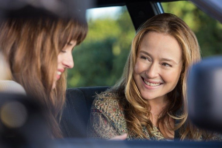 Mamá e hija charlando dentro de un automóvil, ambas sonriendo, mirándose a los ojos, con cabello hasta los hombros en tonos dorados, ojos amielados, labios delgados, baradas en medio del bosque