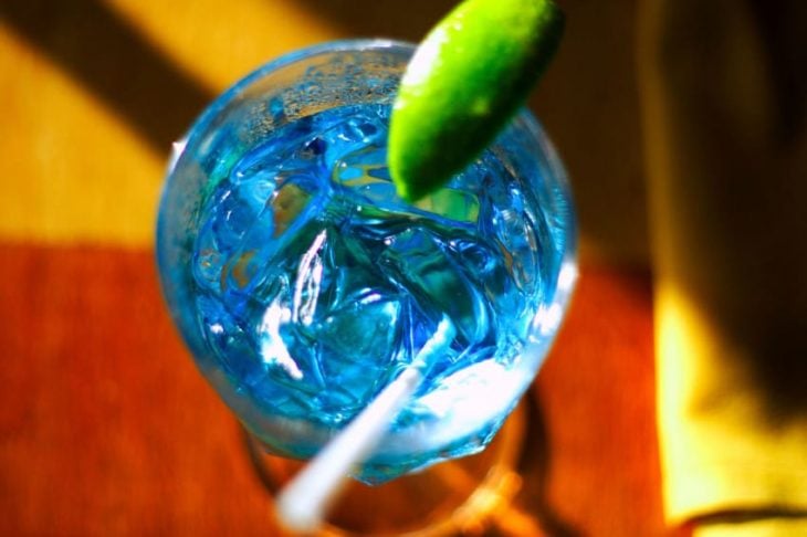 Bebida alcohólica de color azul con limón 