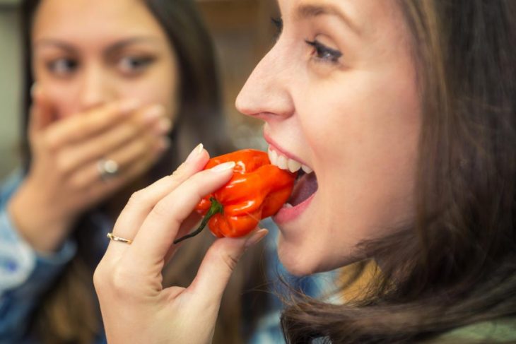 Chica comiendo chile rojo