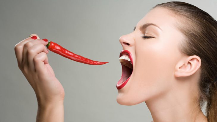 Chica comiendo chile rojo