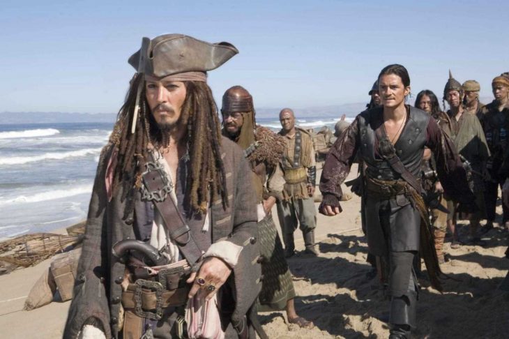 Escena de piratas caminando por la playa en la película Piratas del Caribe: El cofre de la muerte