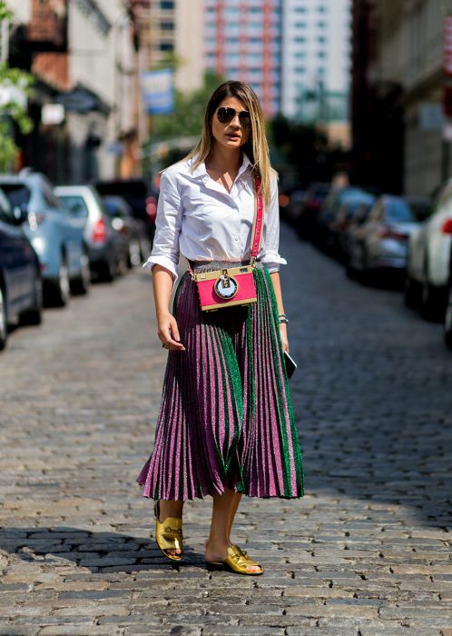 Chica usando una falda larga mientras posa para una foto en la calle 