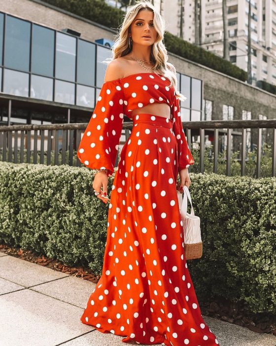 Chica usando una falda larga mientras posa para una foto en la calle 