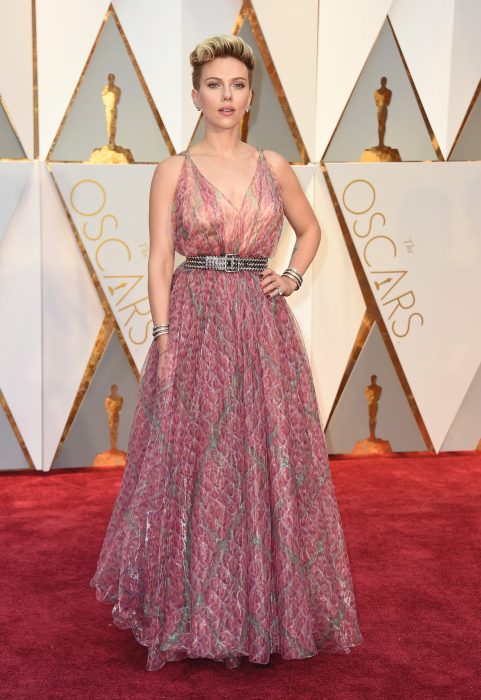 Scarlett Johansson usando un vestido rosa con toques plateados durante la alfombra roja de los premios Óscar 