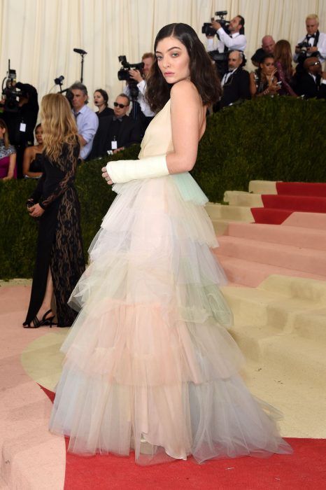 Cantante Lorde usando un vestido de capas en colores pastel en la alfombra roja de los Met Gala 