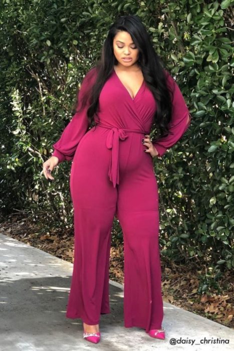 Chica de tez morena curvy modelando un jumpsuit color rosa 