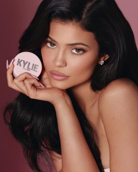 Kylie jenner sosteniendo un polvo translucido de su línea de maquilaje 