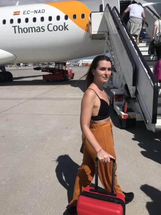 chica llevando su maleta para subir al avión