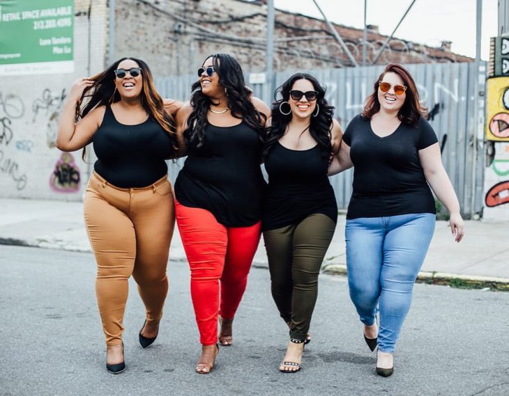 Mejores amigas caminan por la calle abrazadas y sonriendo, mujeres con sobrepeso felices